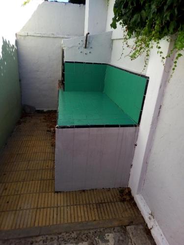 un banco verde sentado a un lado de una pared en jasima en San Isidro
