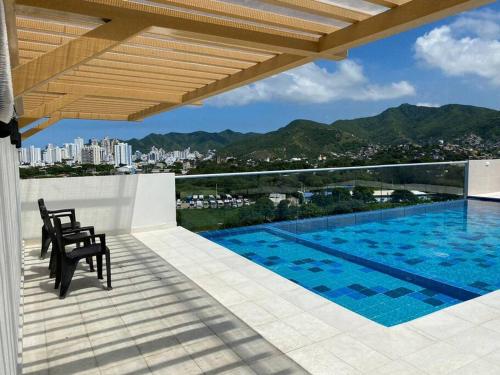 Un balcón con piscina en un edificio. en Con Piscina, Cómodo y acogedor Apartaestudio en el rodadero, en Gaira