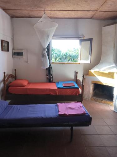 two beds in a room with a window at Casa rural cerca del Cabo in Rincón de los Oliveras