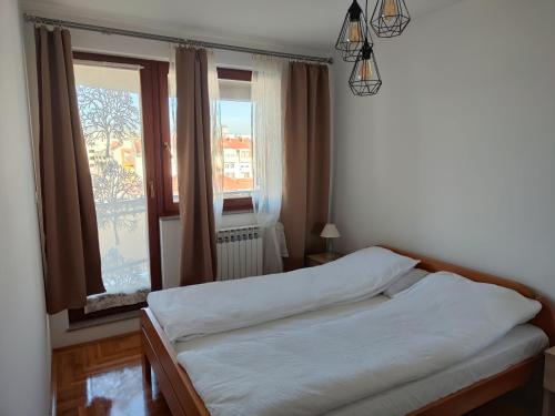 a bedroom with a bed and a window at Apartman Dobrinja in Sarajevo