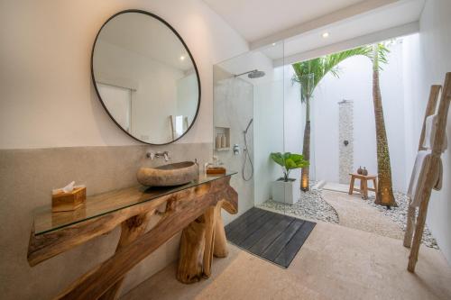 La salle de bains est pourvue d'un lavabo et d'un miroir. dans l'établissement Villa Savana Ubud, à Ubud