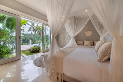 - une chambre avec un lit blanc et des moustiquaires dans l'établissement Villa Savana Ubud, à Ubud