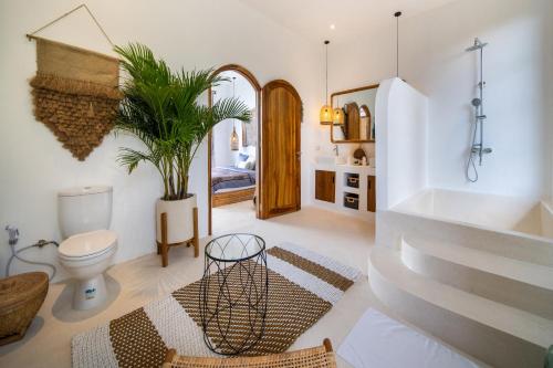 La salle de bains est pourvue de toilettes et d'une plante. dans l'établissement Villa Moonlight Lovina, à Buleleng