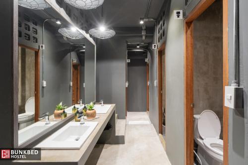 uma casa de banho com 2 lavatórios e um WC em Bunkbed Hostel em Makkasan