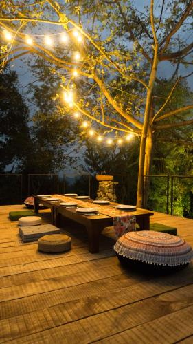 a wooden deck with a picnic table and lights at Ella Nine Peaks in Ella