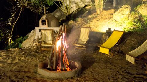 a fire pit with chairs around it at night at Ella Nine Peaks in Ella