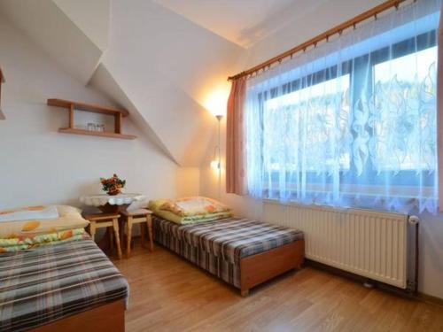 uma sala de estar com duas camas e uma janela em Gospodarstwo Agroturystyczne Watra em Koninki