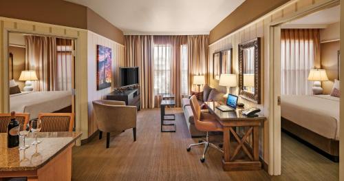 a hotel room with a bed and a desk at Sonesta Suites Scottsdale Gainey Ranch in Scottsdale