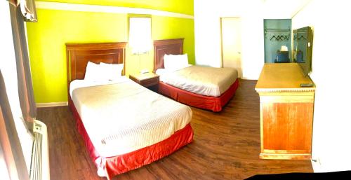 a hotel room with two beds and wooden floors at Hotel M Morgantown - WVU Area in Morgantown