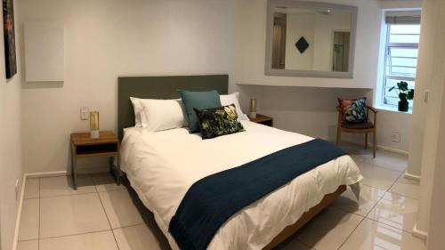 um quarto com uma cama grande com almofadas em Villa 17 - Spacious Apartment in Green Point na Cidade do Cabo