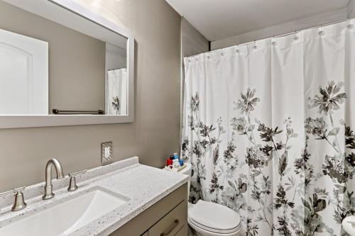 a bathroom with a sink and a shower curtain at Cottage By David Rigney Real Estate Solutions in Lake Geneva
