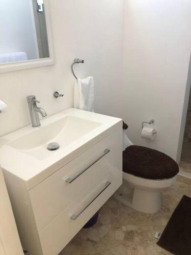 a bathroom with a white sink and a toilet at Penthouse Armando's Le Club in Acapulco