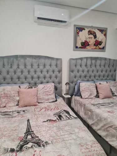a bedroom with two beds and a tufted headboard at Penthouse Armando's Le Club in Acapulco