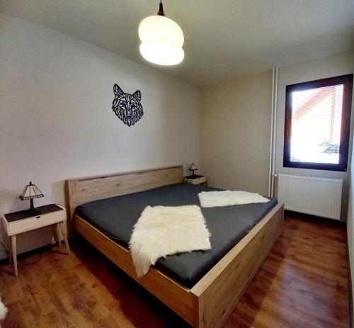een slaapkamer met een bed met een wolvenbord aan de muur bij Vila Devana in Javorina