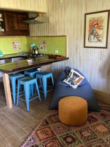 a kitchen with a couch and a table with stools at Departamento La Solar 1 ambiente in Frutillar