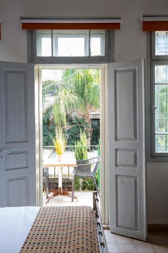 a bedroom with a door open to a patio with a table at Berenice Winery Hotel in Tiberias