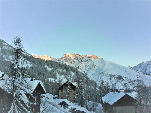 a snow covered mountain with a building and snow covered buildings at PUY SAINT VINCENT APPARTEMENT T2 BALCON SUPER PANORAMA AVEC PARKING PRIVE COUVERT et PISCINE L'ETE in Puy-Saint-Vincent