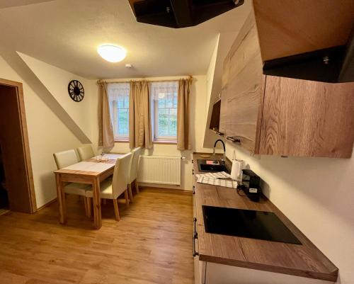 a kitchen with a table and chairs and a dining room at Chata Hubertka Krkonoše in Vítkovice