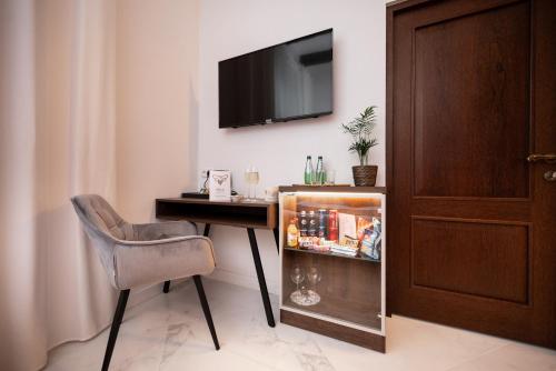 a room with a desk and a chair and a television at Hive Family House in Kraków
