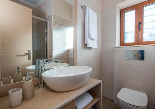 a bathroom with a large white sink and a toilet at Iris Villas Lefkada - Marine Villa in Évyiros