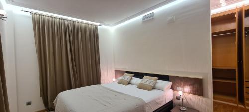 Un dormitorio con una cama blanca grande y una ventana en Port Blau Cambrils, en Cambrils