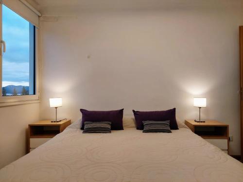 - une chambre avec un grand lit et deux lampes dans l'établissement Amanecer en el Lago, à San Carlos de Bariloche