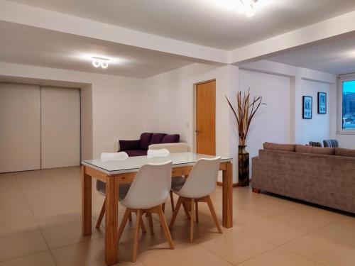 - un salon avec une table, des chaises et un canapé dans l'établissement Amanecer en el Lago, à San Carlos de Bariloche