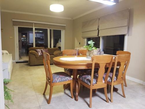 a dining room with a wooden table and chairs at KIKO in Tramandaí