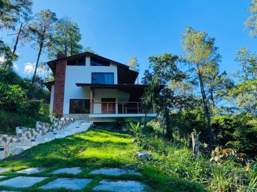 dom na wzgórzu z zielonym ogródkiem w obiekcie Lote 13N (Quintas del Bosque) Los Helechos w mieście Los Corozos