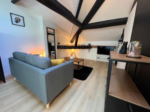 un salon avec un canapé bleu et une table dans l'établissement Le Germinal - Studio climatisé calme proche du métro, à Toulouse