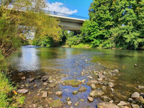 a river with rocks and a bridge in the background at Schöne Doppelzimmer in Rheine