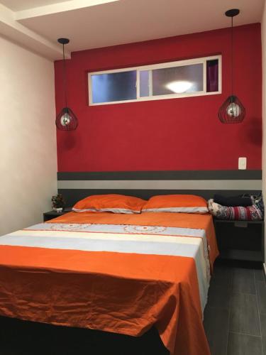 Un dormitorio con una pared roja y una cama en Para groupos y familia grande los molinos laurles, en Medellín