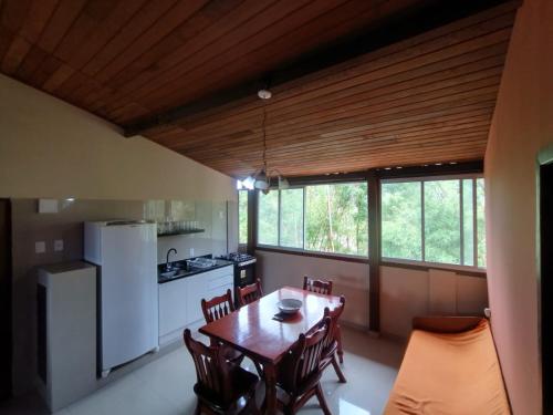 eine Küche und ein Esszimmer mit einem Tisch und Stühlen in der Unterkunft Apart da Cachoeira in Florianópolis