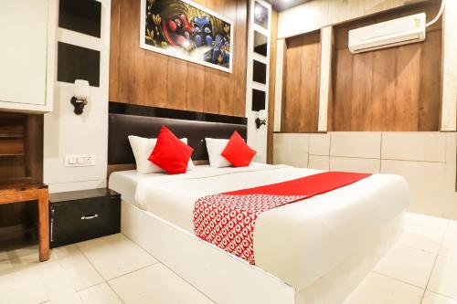 - une chambre avec un lit et des oreillers rouges dans l'établissement Hotel Sheela, à Rohtak