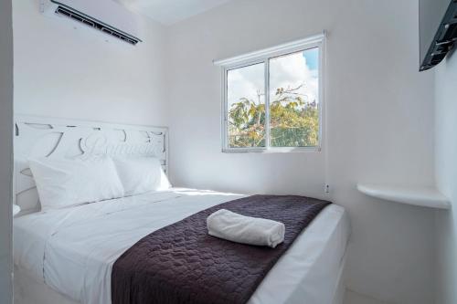 um quarto branco com uma cama e uma janela em Italia Estación Hotel, Merida em Mérida