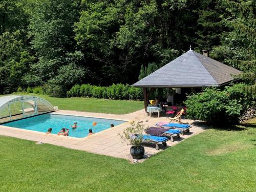 a group of people in a swimming pool with a gazebo at LE CLOS DU TULIPIER in La Chapelle-du-Bard