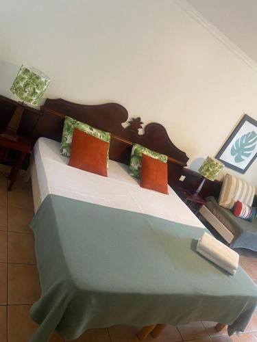 a bedroom with a bed with pillows and a couch at Village Ste luce - Olivera Studio in Sainte-Luce