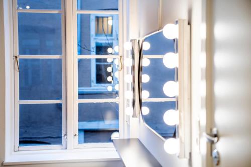 a bathroom mirror with a view of a window at The Townhouse by Daniel&Jacob's in Copenhagen