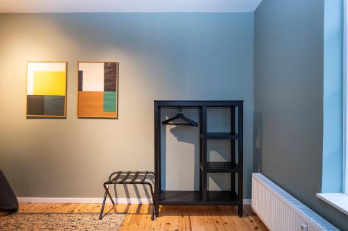 a room with a shelf and three paintings on the wall at The Townhouse by Daniel&Jacob's in Copenhagen