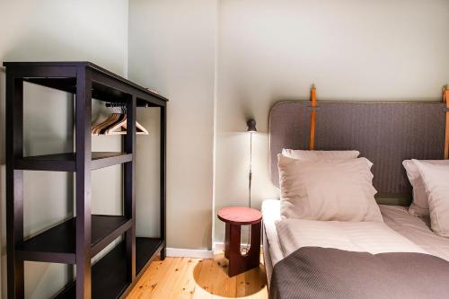 a bedroom with a bed and a book shelf next to a bed at The Townhouse by Daniel&Jacob's in Copenhagen