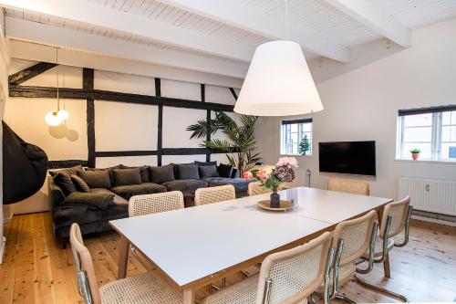 uma sala de estar com uma mesa branca e cadeiras em The Townhouse by Daniel&Jacob's em Copenhague