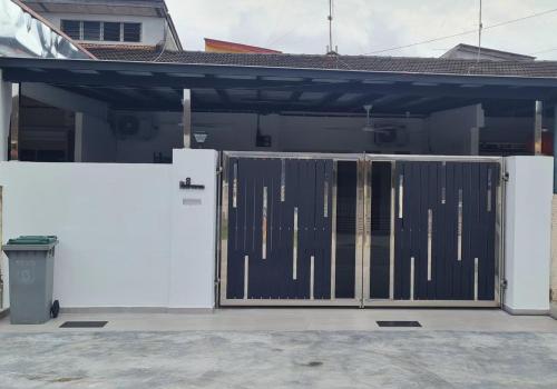 un garaje con una puerta delante de una casa en Batu Pahat Taman Banang Homestay en Batu Pahat