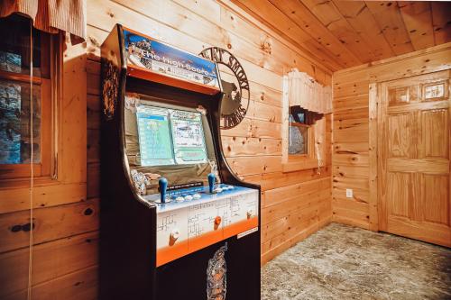 a wooden room with a video game machine in it at Sugar Bear Cabin in Sevierville