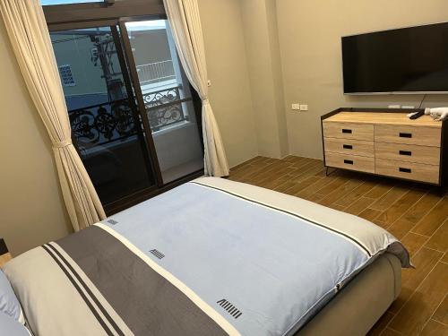 1 dormitorio con 1 cama y TV de pantalla plana en An Egg Homestay en Beipu
