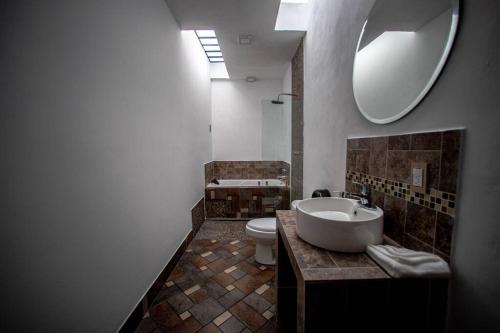 a bathroom with a sink and a toilet and a mirror at Casa San Pancho Centro Mágico in Pátzcuaro