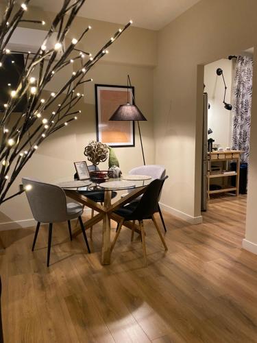 a dining room with a table and chairs and a tree with lights at SIMONE LUXURY SUITE, Central Modern Apartment 82sqm with Terrace in Tripolis