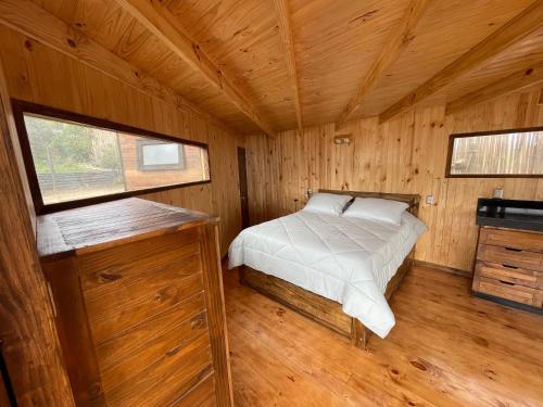 a bedroom with a bed in a wooden cabin at Casa al mare uno - Matanzas y Pupuya in Navidad