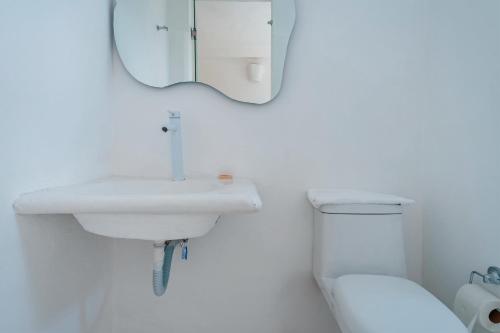 a white bathroom with a sink and a toilet at Italia Estación Hotel, Merida in Mérida