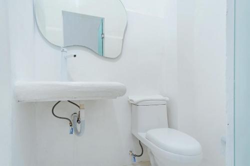 a white bathroom with a mirror and a toilet at Italia Estación Hotel, Merida in Mérida