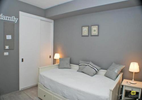 - une chambre avec un lit blanc et des oreillers dans l'établissement Apartamento Estrella Dominicus, à La Laguna